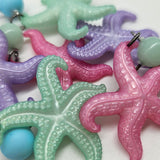 Colorful starfish earrings on a white background