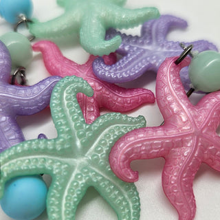 Colorful starfish earrings on a white background