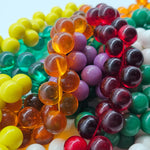 A jumble of several colorful beaded necklaces.