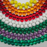 Multiple colorful beaded necklaces laid out on a white background.