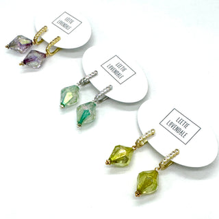Set of earrings with green and purple gemstones on white cards with 'Leete Lovendale' branding.
