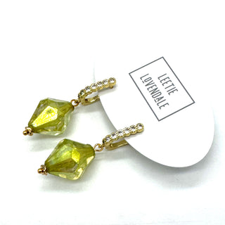 Gold earrings with green gemstones on a white background