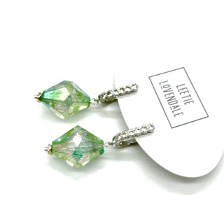 Green crystal earrings with silver hooks on a white background, featuring the brand 'Leette Lovendale'.