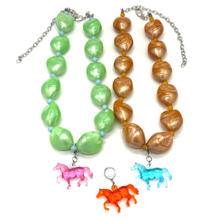 Two necklaces with green and brown beads and horse charms on a white background