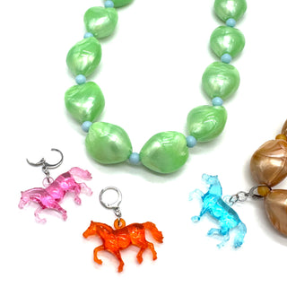 Necklace with green beads and horse-shaped charms on a white background