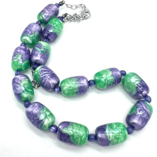Necklace with green and purple beads on a white background