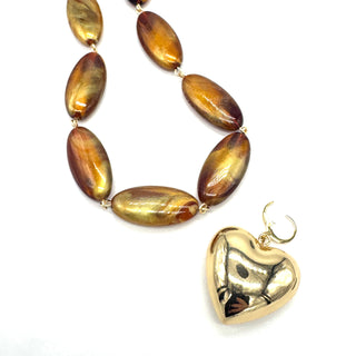 Necklace with brown oval beads and a gold heart pendant on a white background
