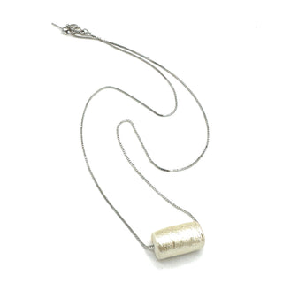 Silver necklace with a cylindrical pendant on a white background