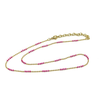 Gold and pink beaded necklace on a white background
