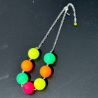 Neon bead necklace on a dark surface