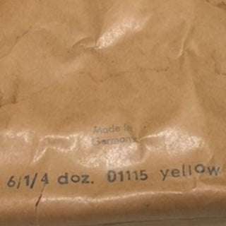 Close-up of brown paper with text 'Made in Germany 61/4 doz. 0115 yellow' on a textured background.