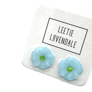 Light blue flower-shaped earrings on a card with 'Leetie Lovendale' branding.