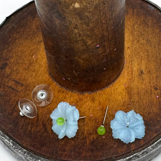 Flower-shaped earrings on a wooden stand