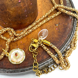 Gold necklace with a pendant on a wooden surface