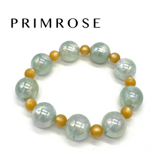 Beaded bracelet with white and gold beads on a white background, featuring the brand 'Primrose'.