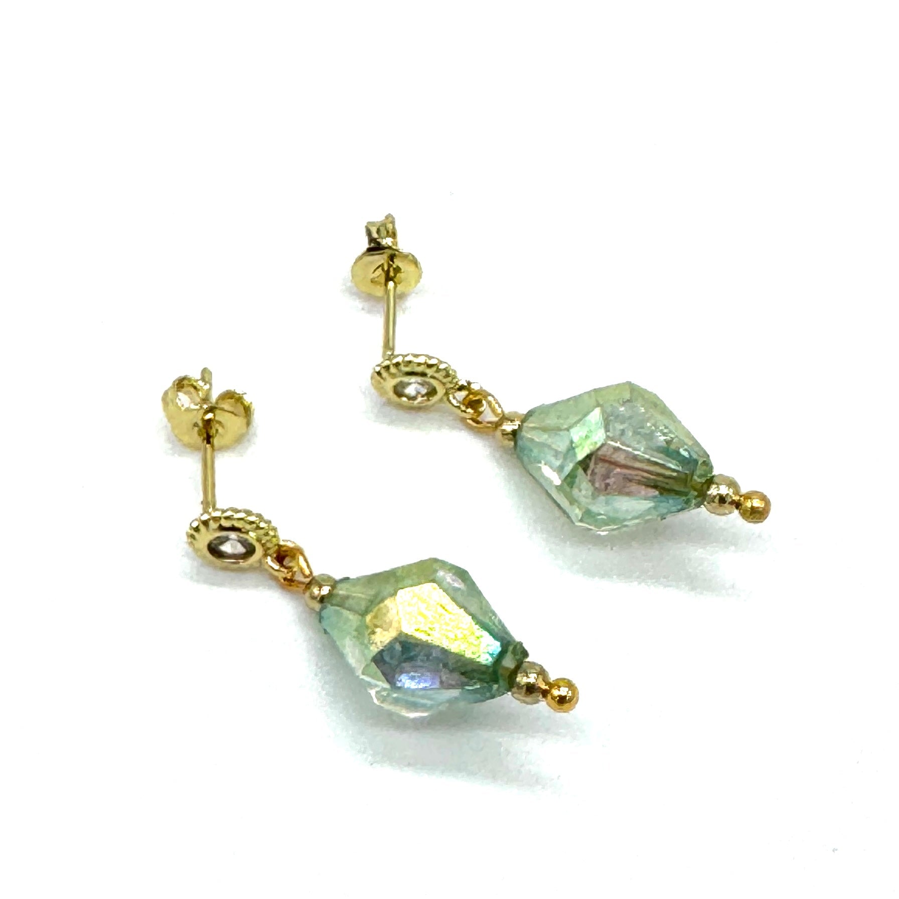 Gold earrings with green AB lucite drops on a white background