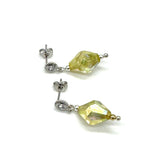 Pair of earrings with lime green lucite beads on a white background