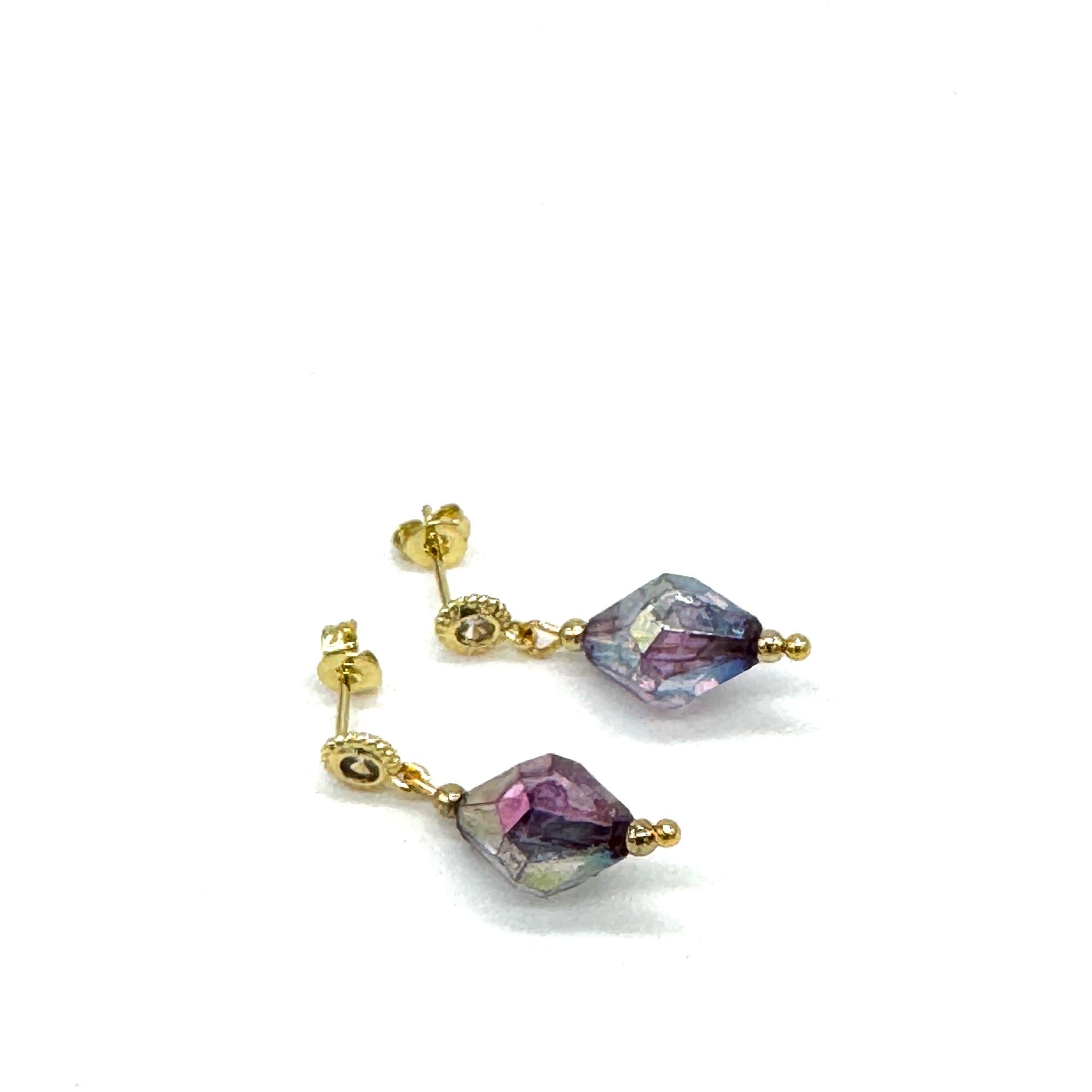Pair of earrings with purple lucite beads on a white background