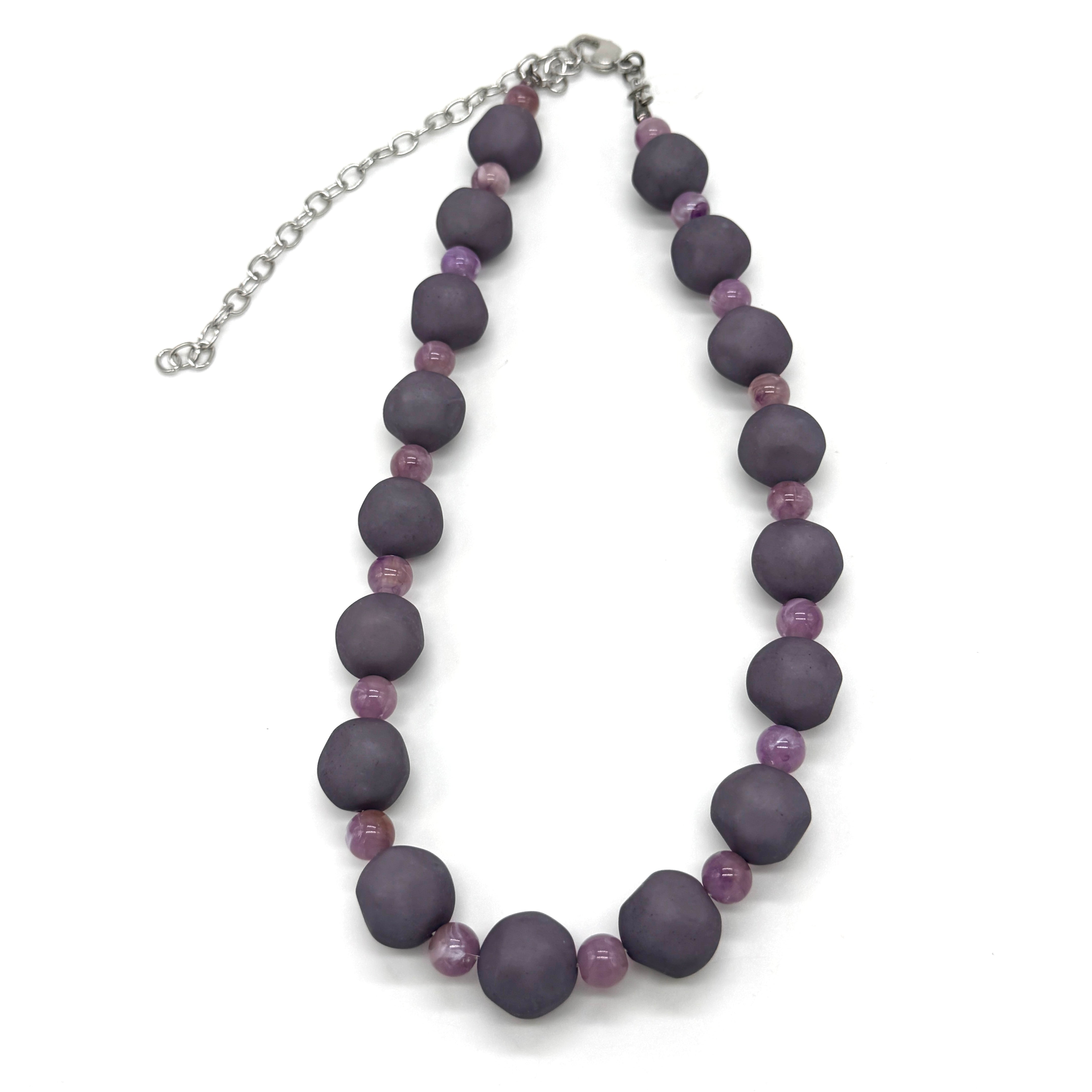 Adjustable necklace featuring dark gray and lilac lucite beads laid on a white background.