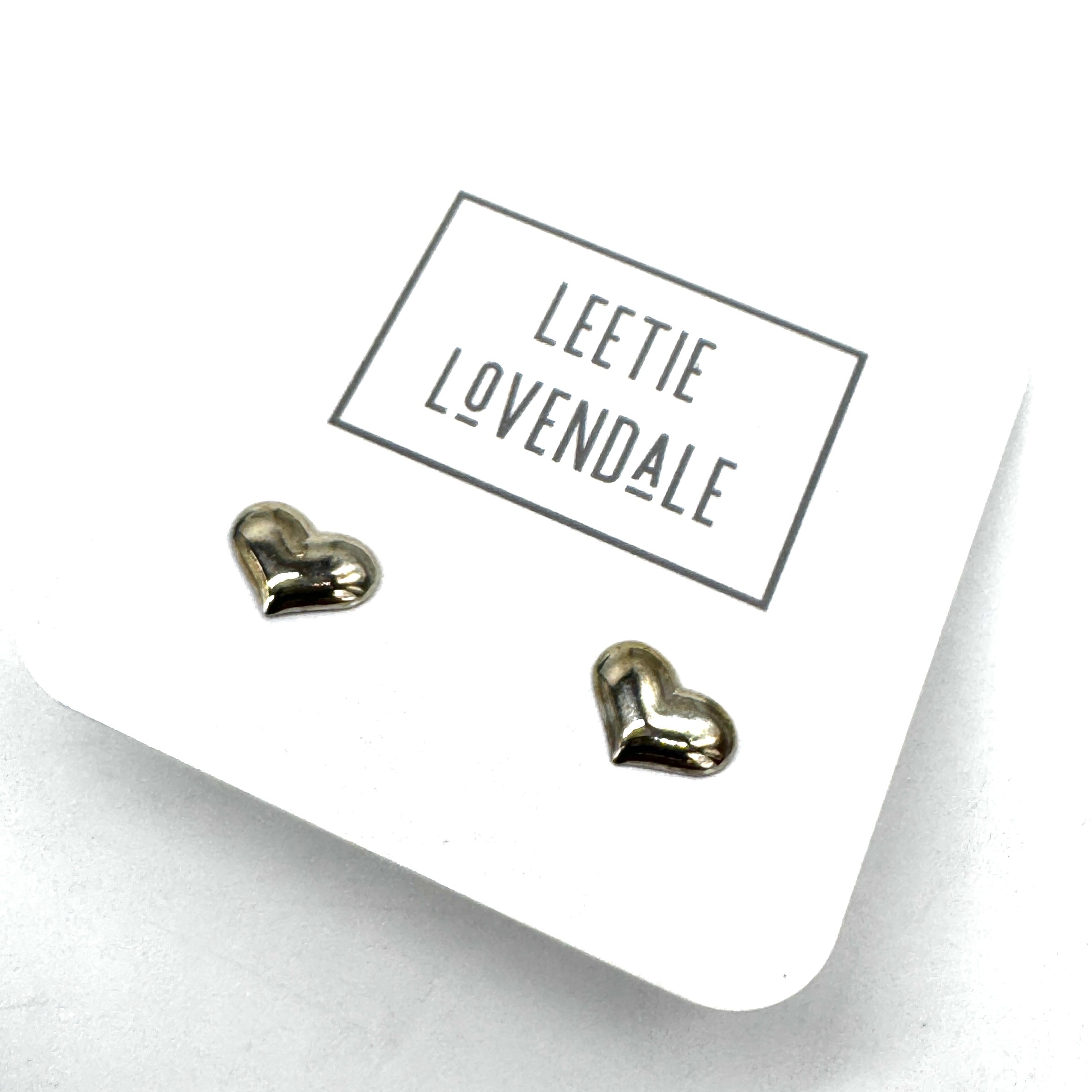 Heart-shaped earrings on a white card with 'Leetie Lovendale' branding.