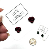 Rose-shaped earrings on a 'Leetie Lovendale' branded card with a coin for size comparison.