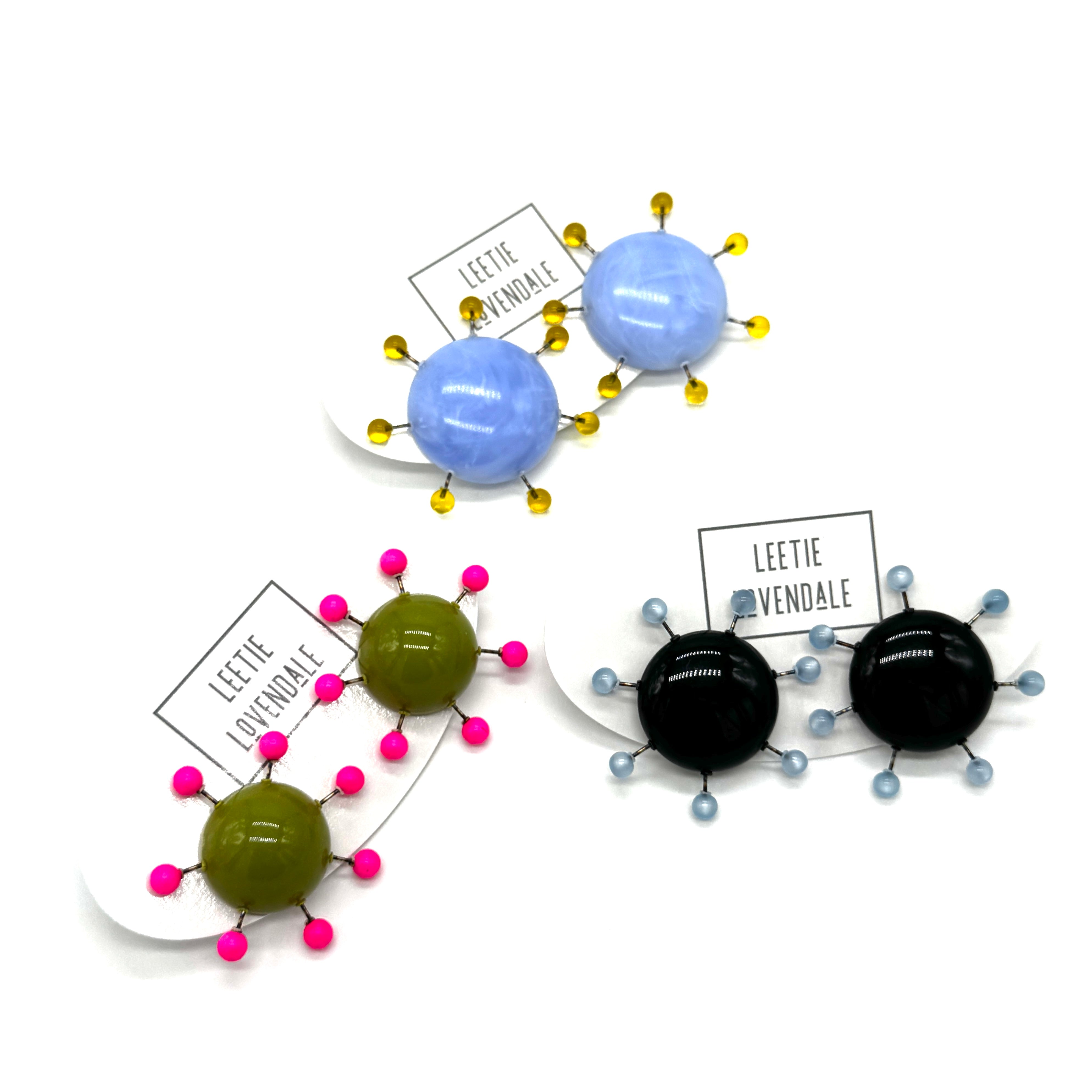 Colorful sculptural earrings with 'Leetie Lovendale' labels on a white background