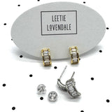 Silver and gold crystal hoop earrings on branded earring cards.