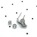 Silver and crystal hoop earrings on a polka dot background.