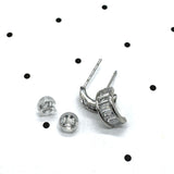 Silver and crystal hoop earrings on a polka dot background.