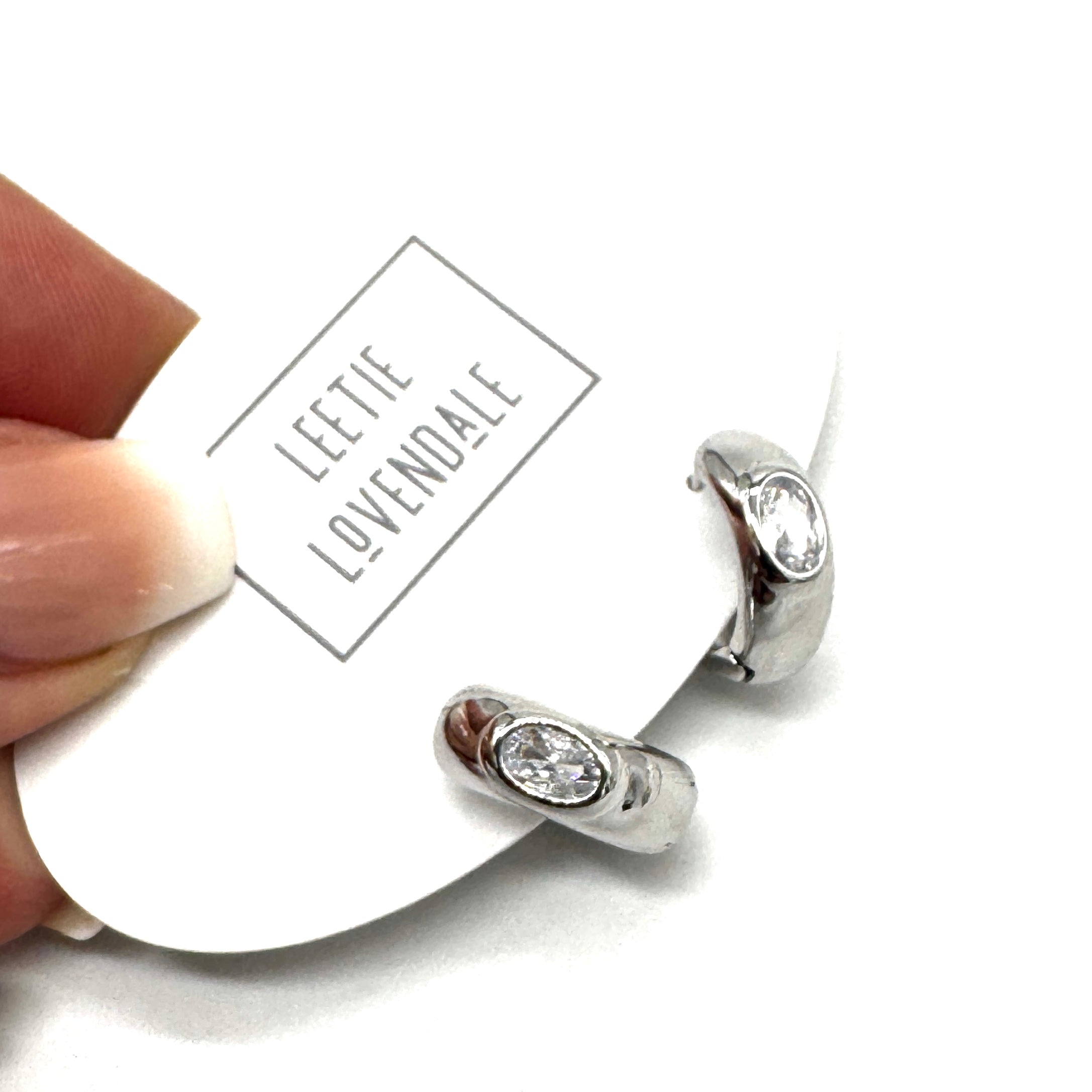 Silver and crystal hoop earrings on an earring card.