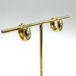 Gold hoop earrings with a crystal set in the center of each.