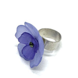 Periwinkle and purple floral cocktail ring on a white background.