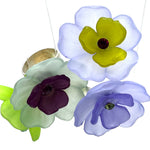Four colorful floral cocktail rings on a white background.