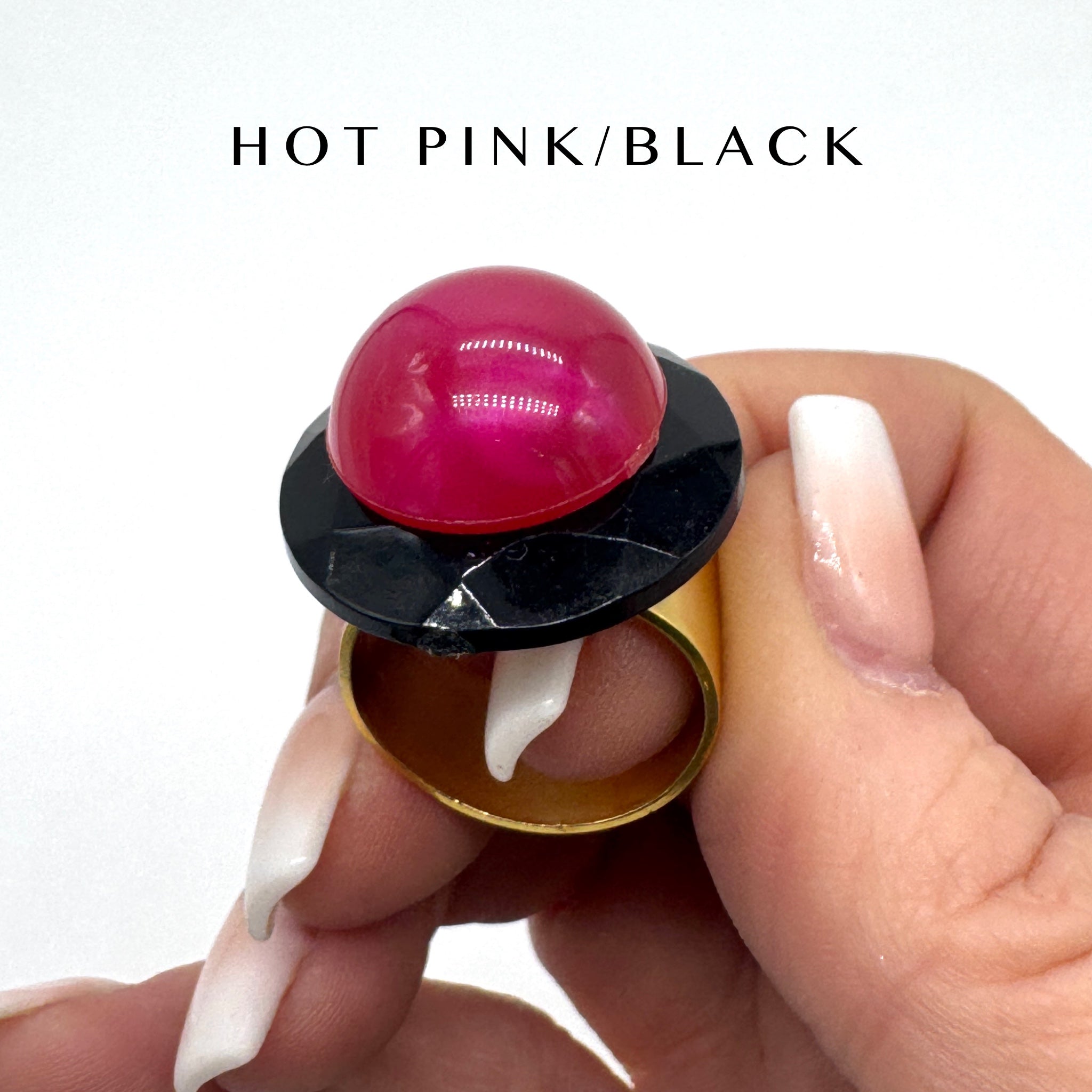 Hand holding a lip balm with a pink cap and black top, labeled 'HOT PINK/BLACK'.
