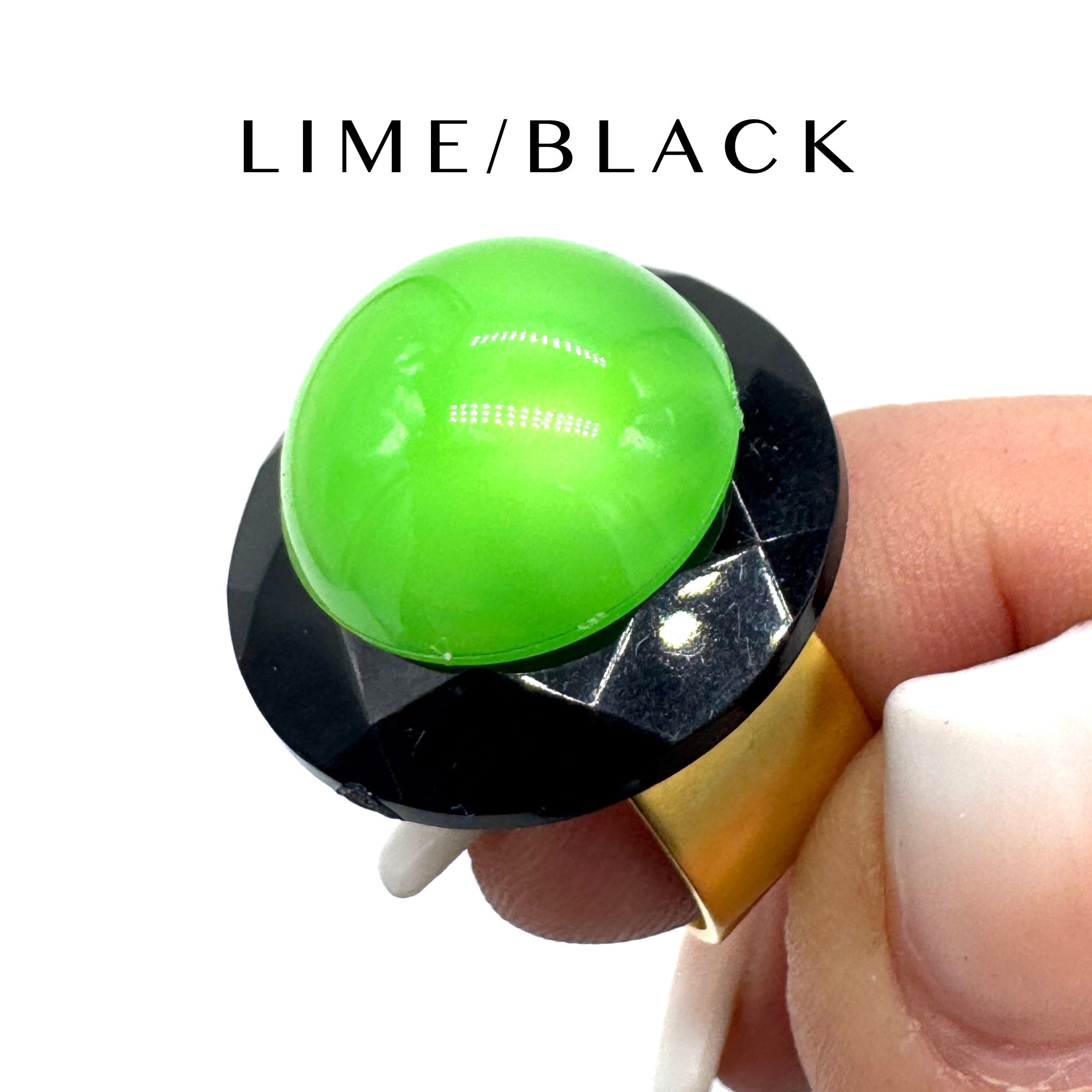 Green and black ring held by a hand with 'LIME/BLACK' text above.