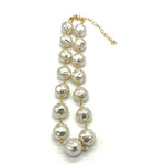 A pearl necklace with textured, hammered white pearls linked by gold-toned chains and connectors, featuring a gold-toned extender chain on a white background.