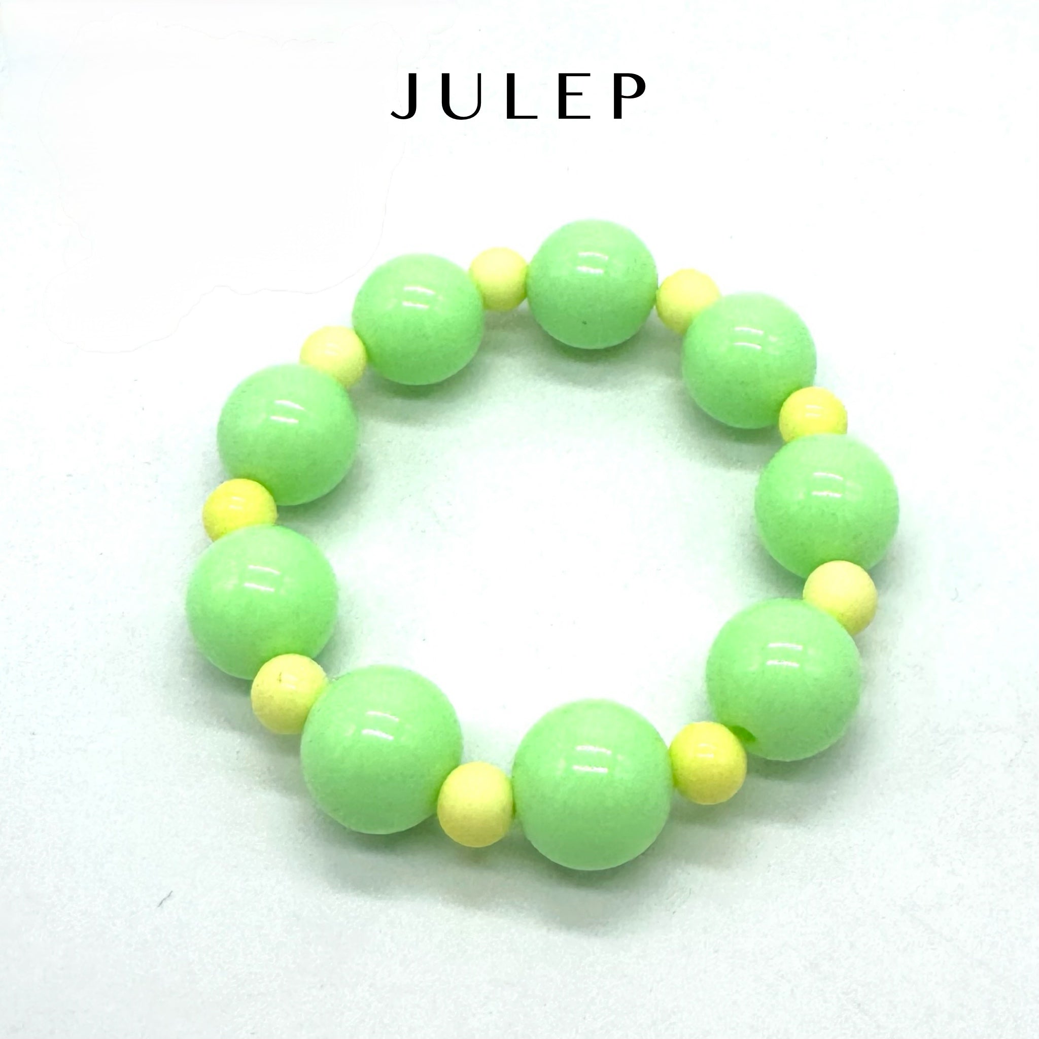 Green and yellow beaded bracelet on a white background with 'JULEP' branding.