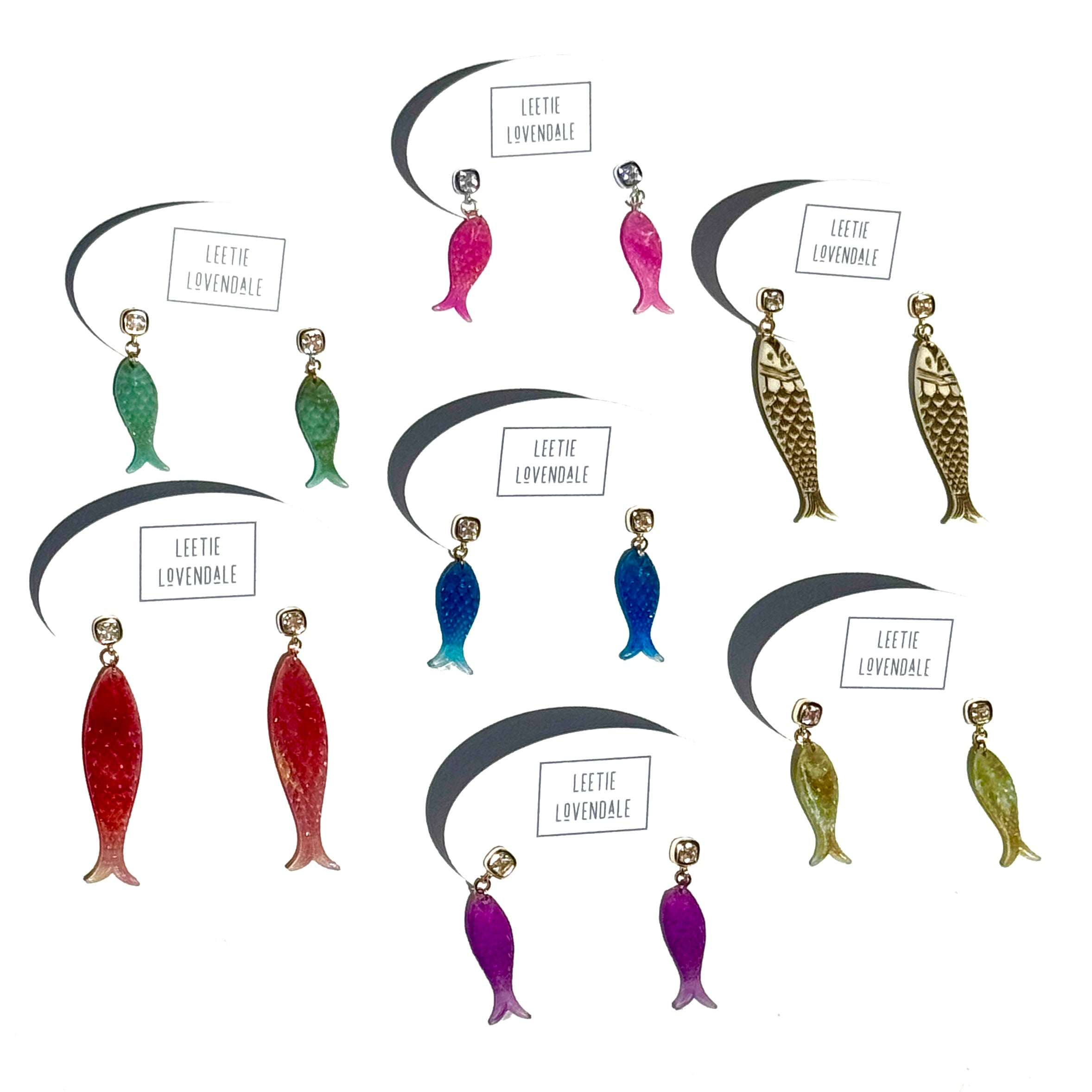 Six pairs of fish-shaped dangling earrings arranged on a white background, each with a small brand label reading 'LEETHE LOVENDALE'. The earrings come in green, blue, red, purple, and gold-tone finishes.