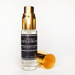 A travel-sized bottle of Ravenclaw Eau De Parfum by House of Cottonwood, with a gold-colored cap and label, displayed next to a gold-colored object, possibly a spray nozzle.