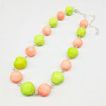 Peach and lime green beaded necklace on a white background.
