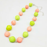 Peach and lime green beaded necklace on a white background.