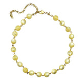 Cream colored moonglow beaded necklace with gold chain on a white background