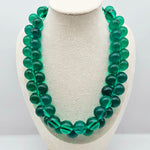 Transparent green beaded necklace on a bust.